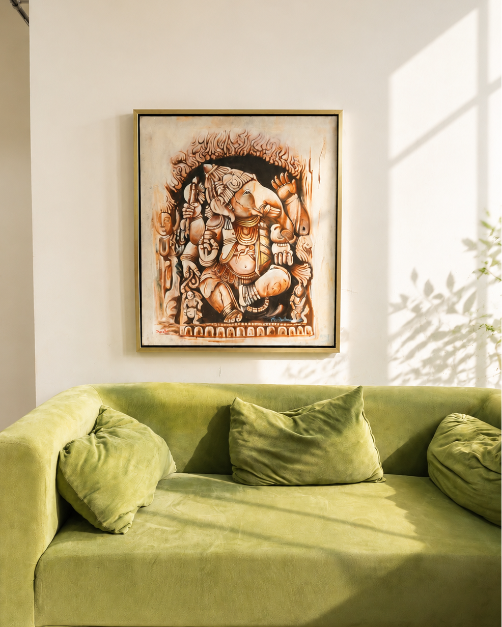 A framed art print depicting a detailed Ganesha illustration in warm earthy tones, hanging on a white wall above a green velvet sofa with pillows.